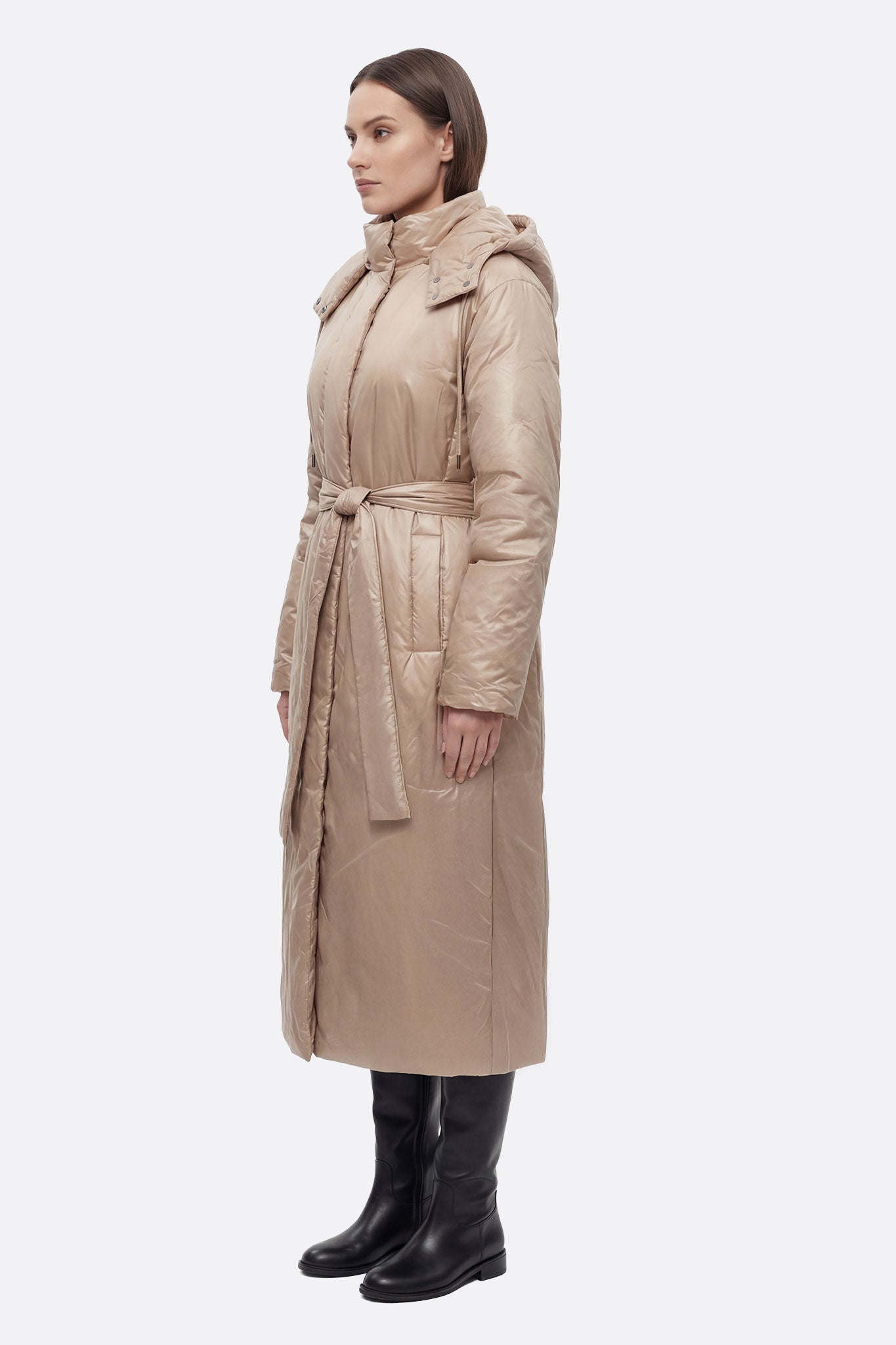 Chaqueta acolchada larga beige brillante con cinturón, vista lateral que resalta su diseño moderno y elegante.