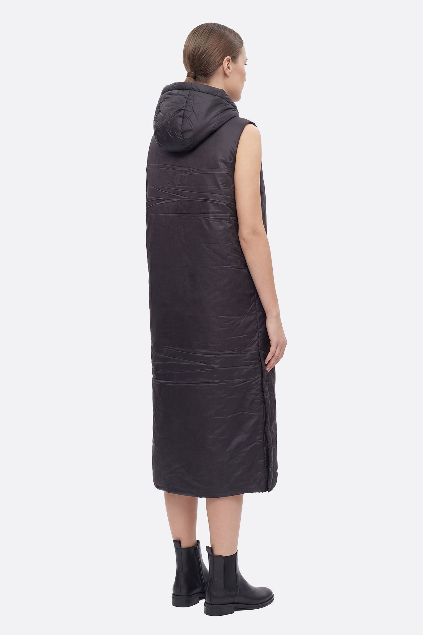 
Détails raffinés de la doudoune noire longue sans manches à capuche, idéale pour des occasions chics tout en restant...



