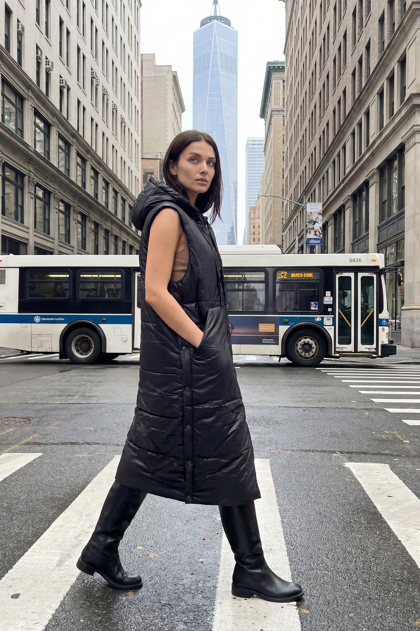 Chaqueta acolchada larga sin mangas negra con capucha, detalle de la textura y diseño moderno, ideal para looks casuales...