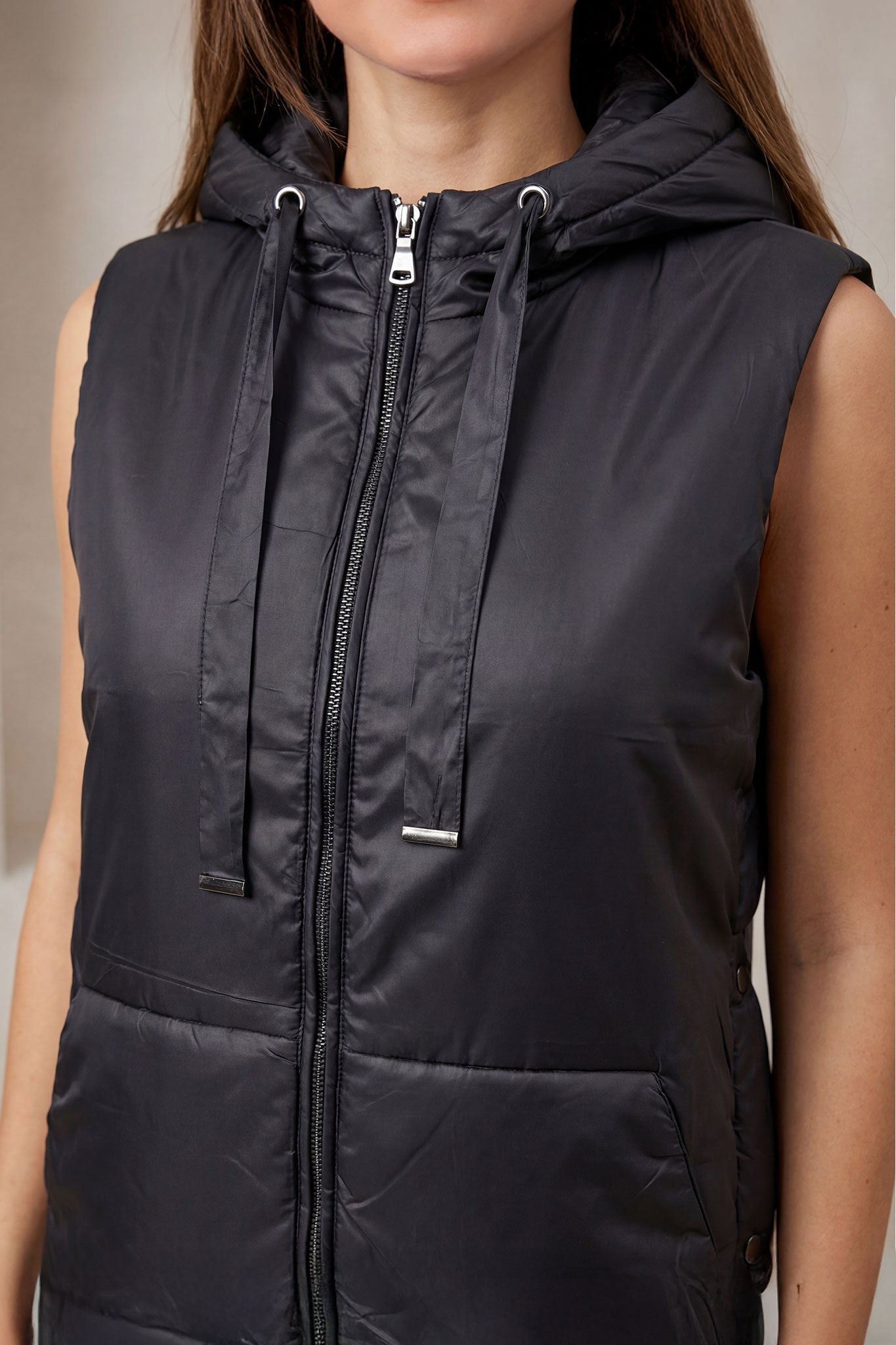 Chaqueta acolchada larga sin mangas negra con capucha, vista alternativa que resalta su diseño ligero y moderno, ideal...