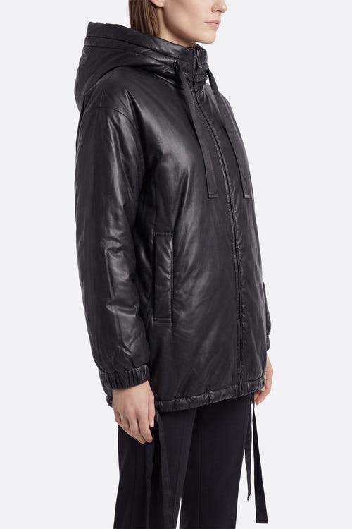 
Doudoune noire matelassée, vue latérale, soulignant ses liens ajustables et son tissu au toucher satiné pour un style...



