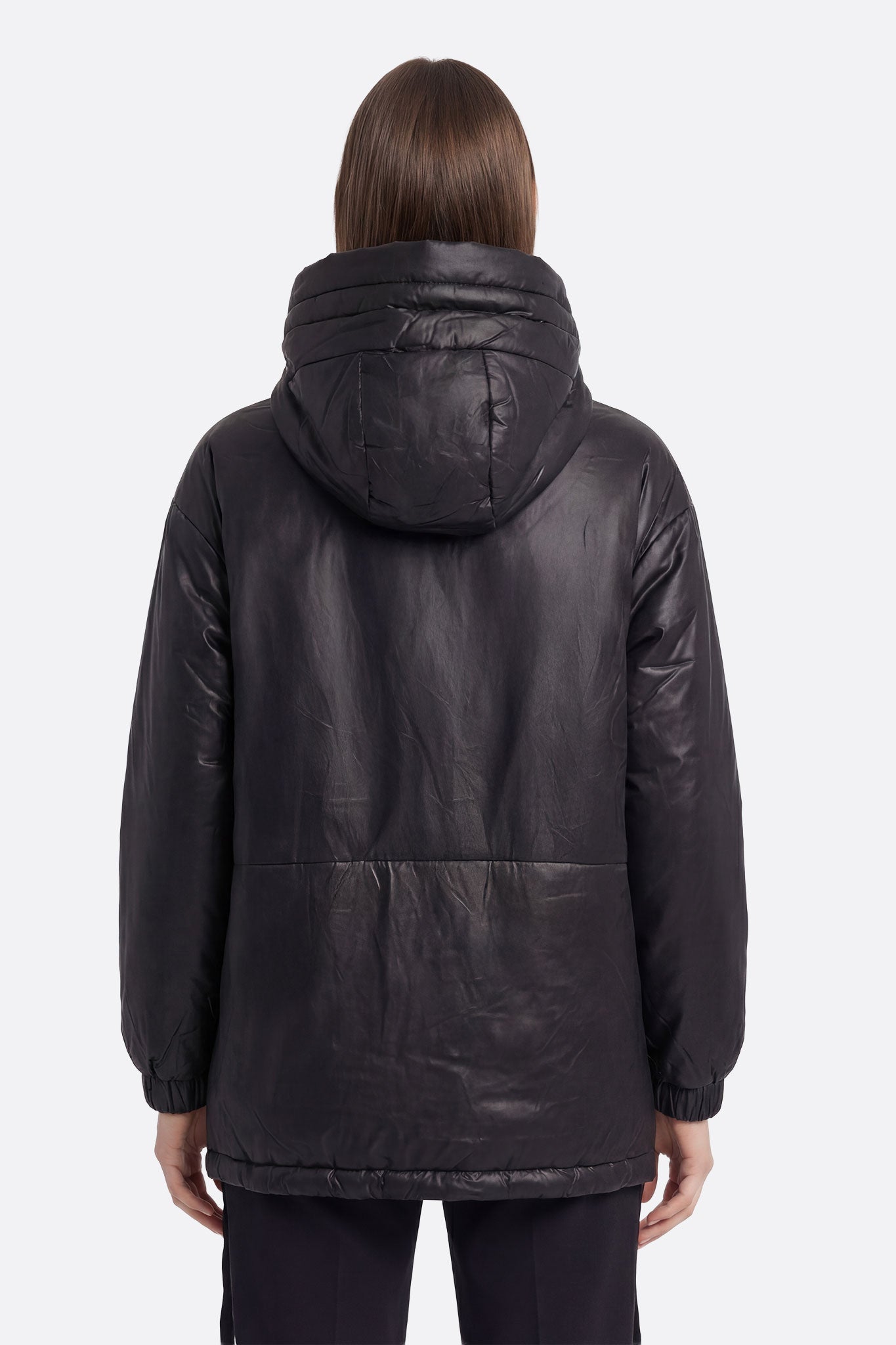 
Doudoune noire matelassée avec capuche, angle légèrement décalé révélant ses liens ajustables et son élégance intemporelle.



