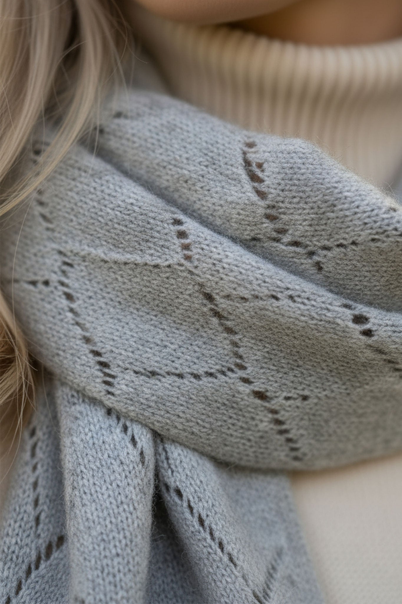 Stylish grey cashmere scarf showcasing a beautiful open-knit pattern, perfect for achieving a sophisticated look during...