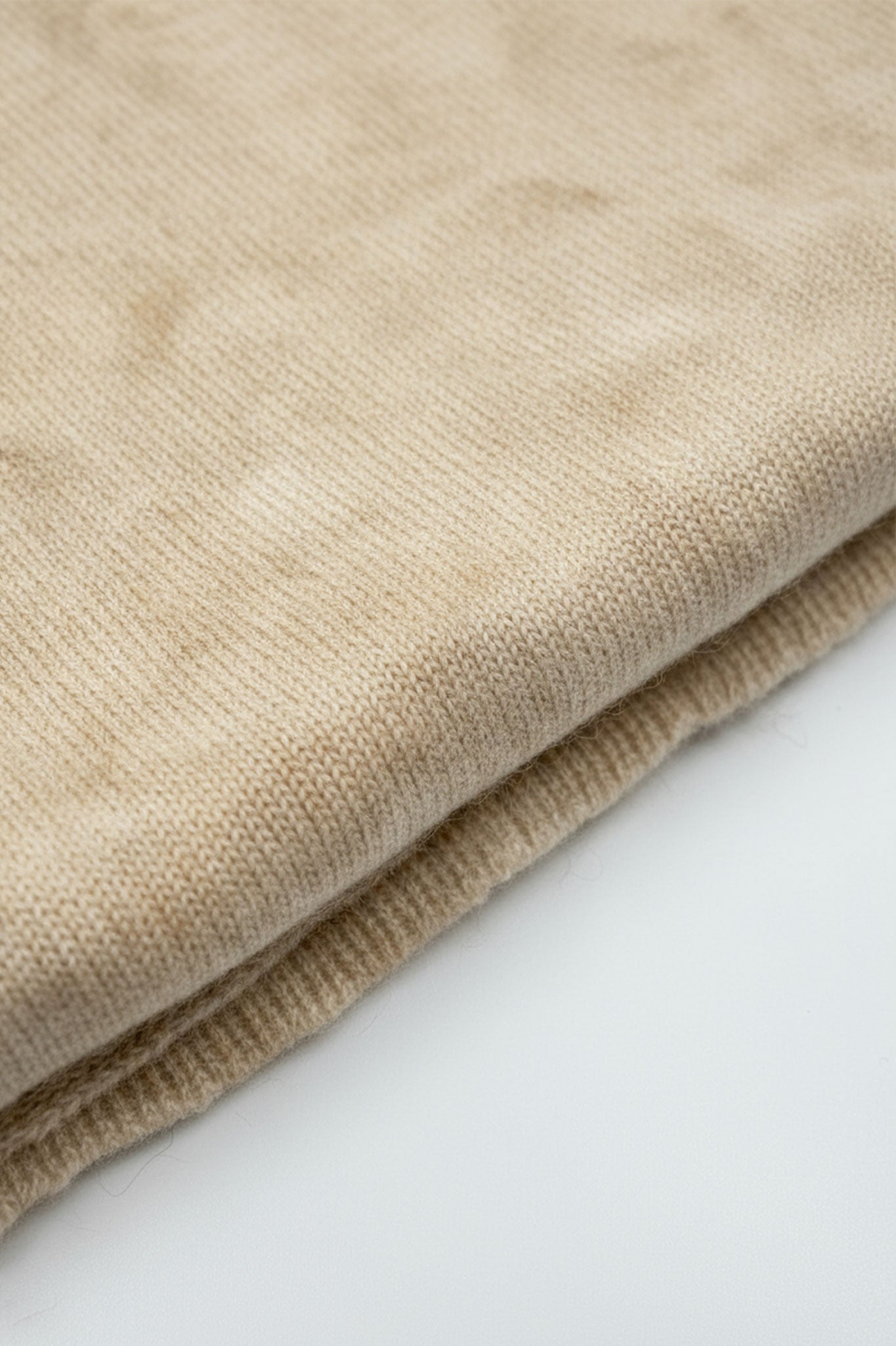 Detailansicht eines edlen beigen Sandfarbene Cashmere-Schals, der mit seiner samtigen Textur perfekte Akzente für...