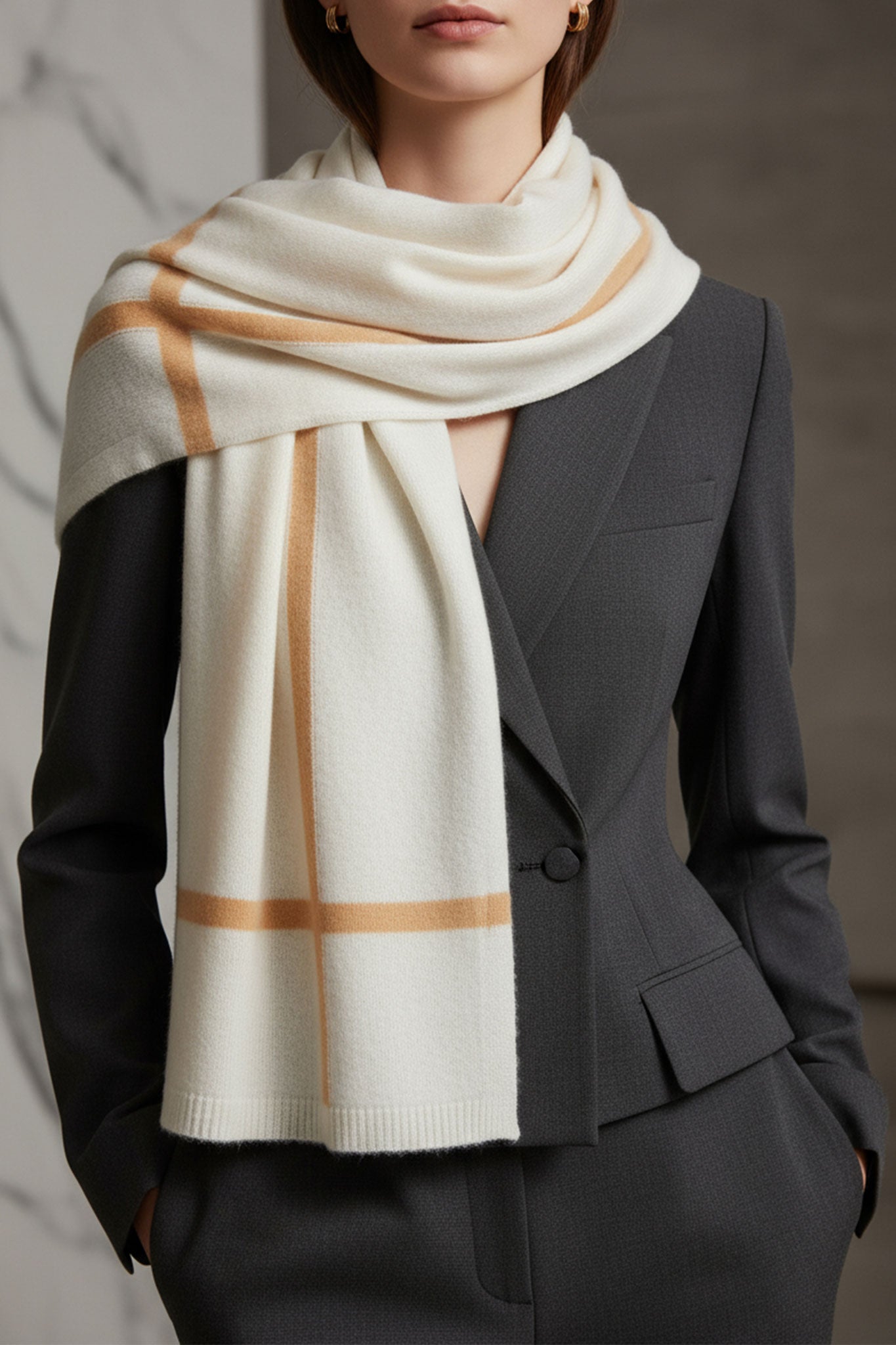 Detalle sofisticado de una bufanda de cachemire blanca con franjas marrones, perfecta para un estilo elegante en...