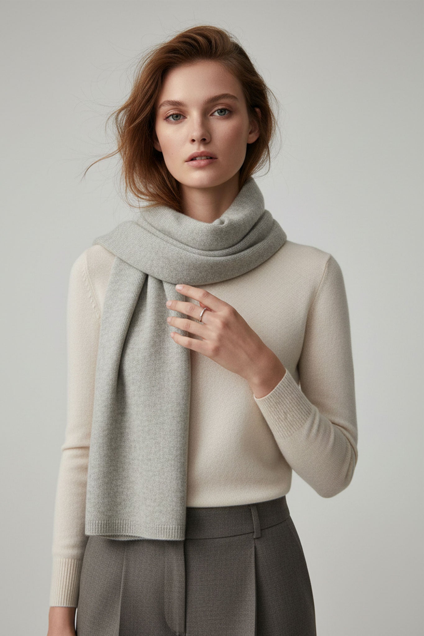 Zoom en la bufanda de cachemira gris perla, resaltando su textura sedosa y elegante, perfecta para un estilo atemporal y...