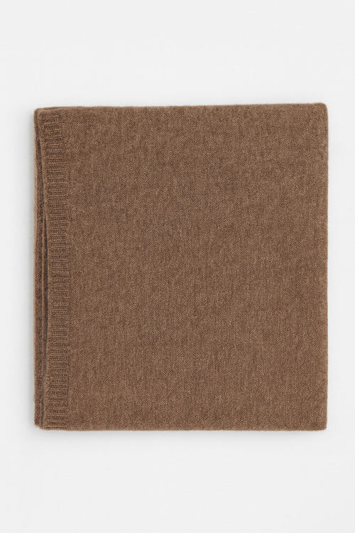 
Zoom sur l'écharpe marron en cachemire, un accessoire élégant qui évoque le confort et le chic pour le quotidien.



