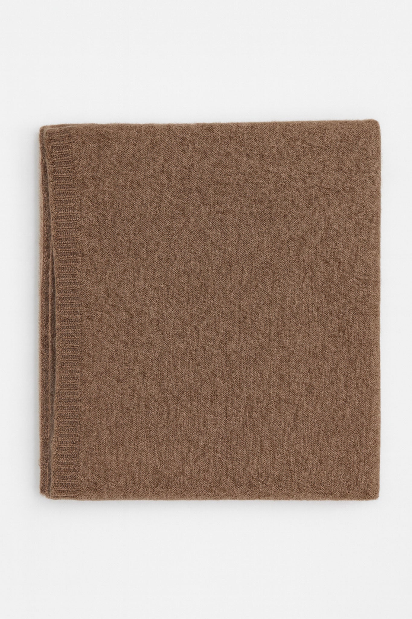 
Zoom sur l'écharpe marron en cachemire, un accessoire élégant qui évoque le confort et le chic pour le quotidien.



