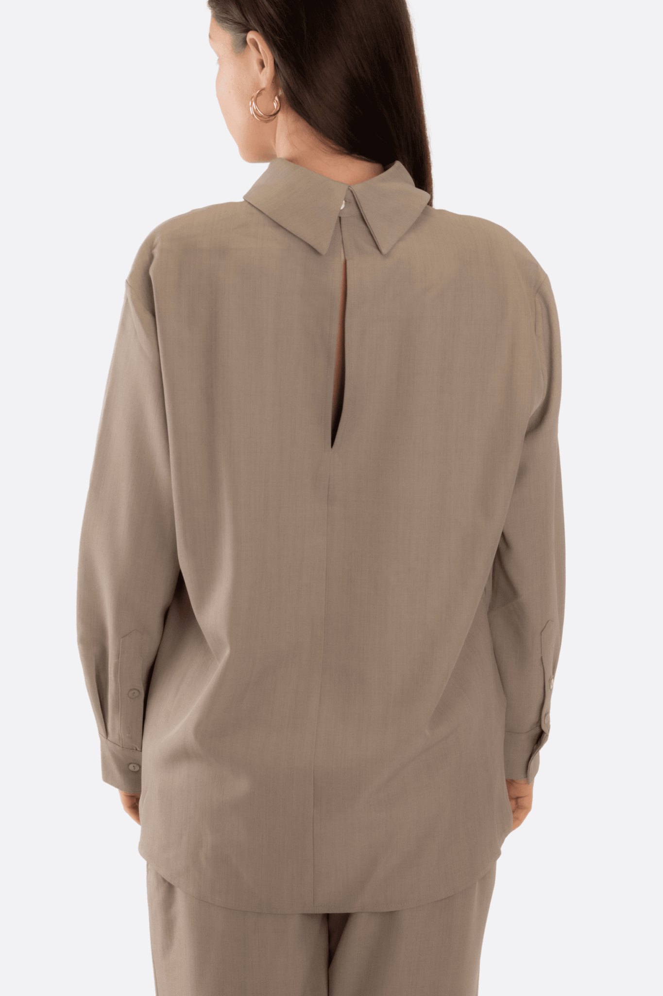 
Détail élégant de l'ensemble gris deux pièces, chemise souple et pantalon ample, idéal pour une allure moderne et stylée.



