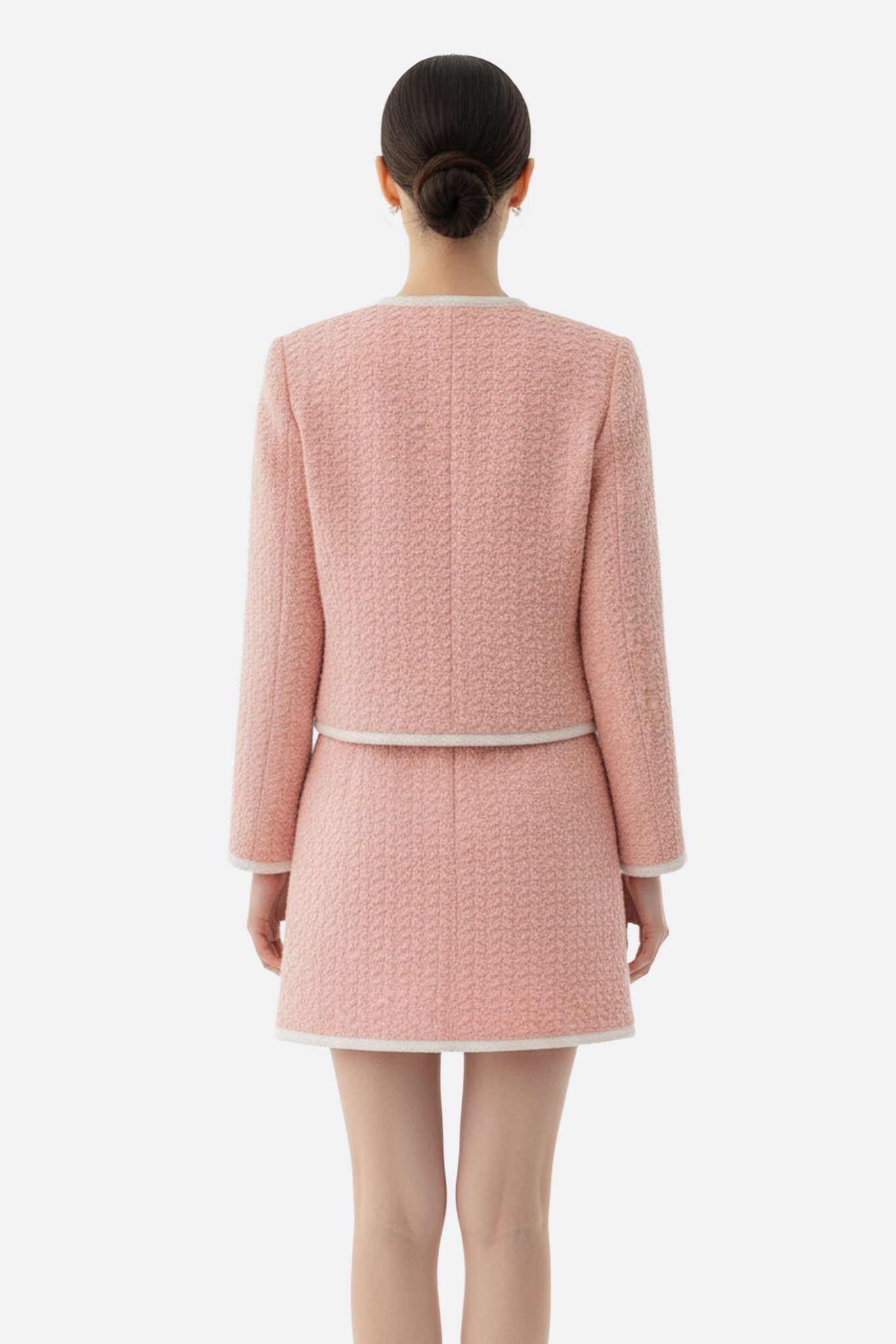 Детали короткой юбки и жакета из розового твида с карманами, создающие шикарный образ для городских вечеринок.