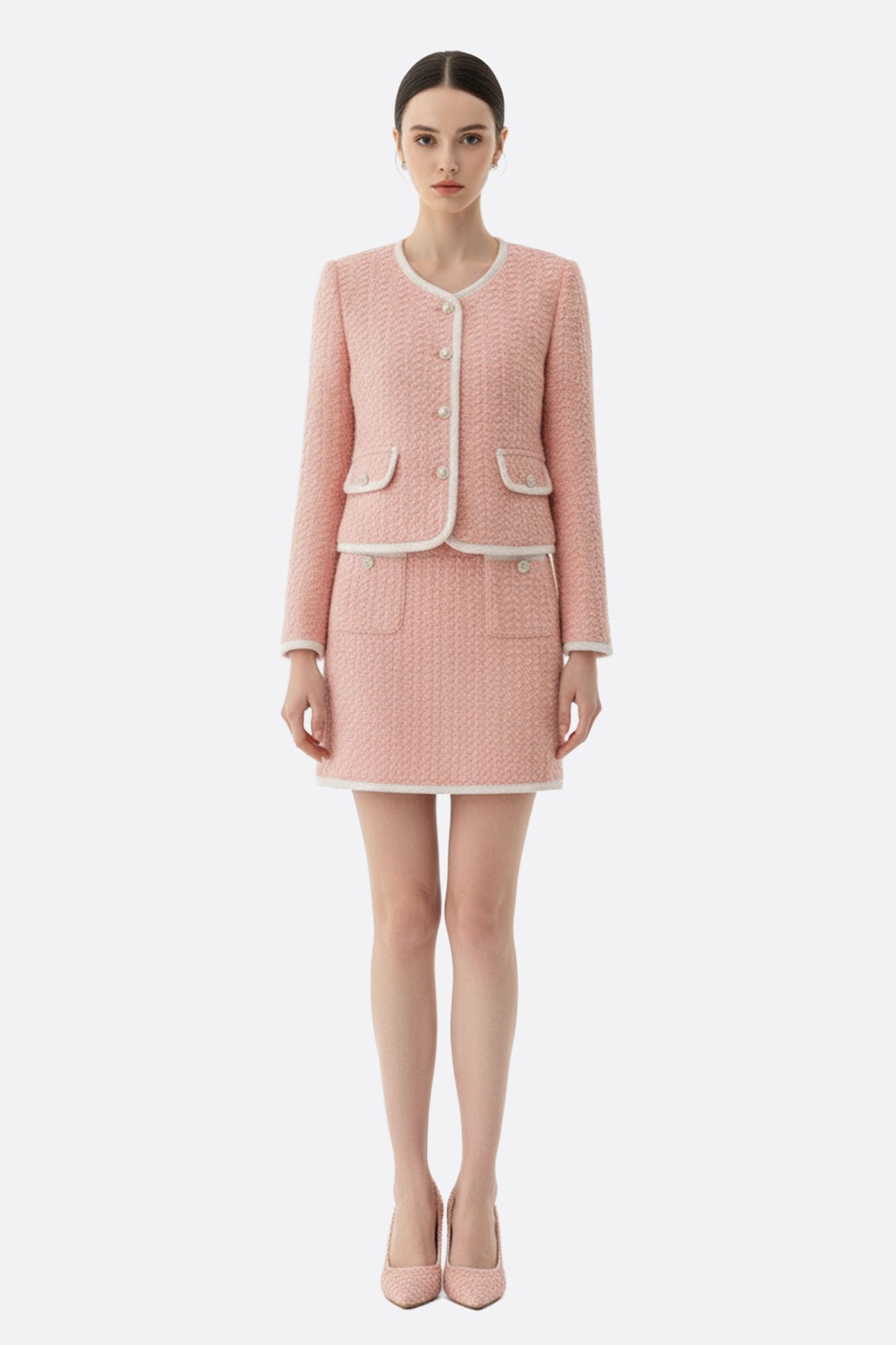 
Détail de la veste à poches en tweed rose, une pièce idéale pour un style élégant lors de vos événements urbains.



