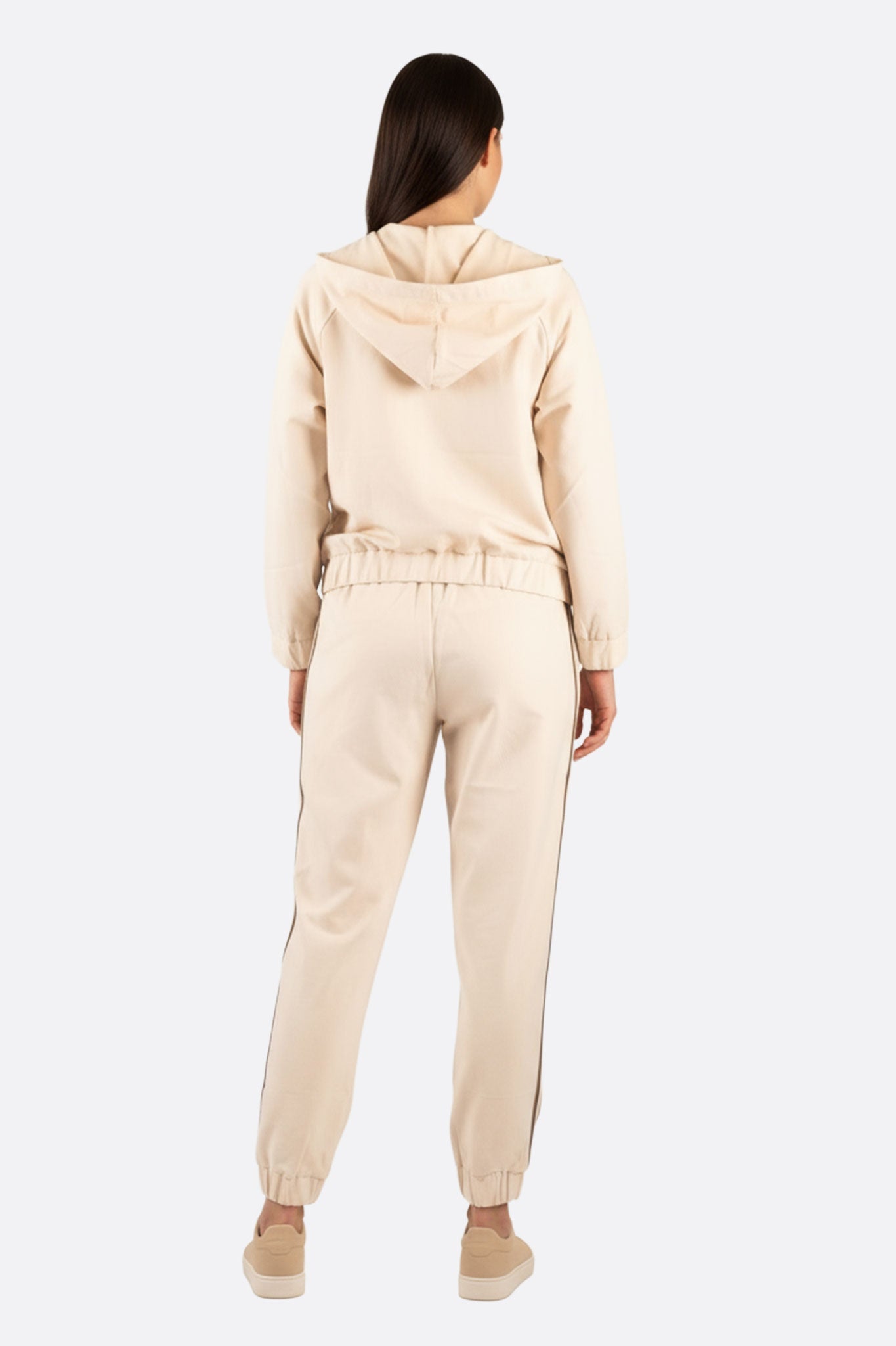 Vista 3/4 dell'ensemble di jogging beige con bande a contrasto, perfetto per un look chic e casual da indossare in ogni...