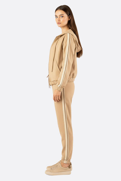 
Détail élégant de l'ensemble de survêtement marron, mettant en valeur les bandes latérales sophistiquées pour un style...



