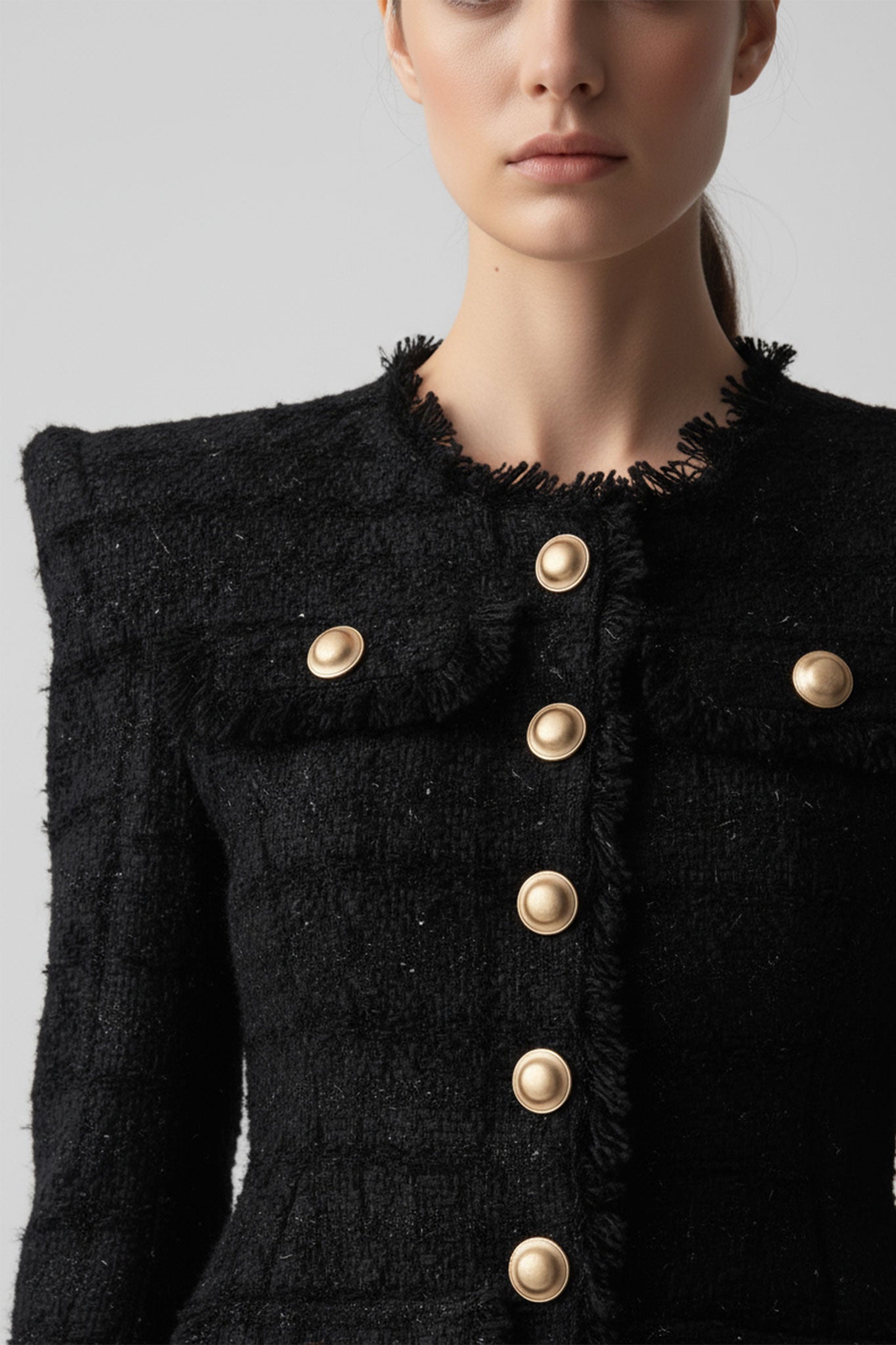 
Fermeture délicate de la veste en tweed noir pour femme, ajoutant une touche d'élégance pour des occasions spéciales ou...



