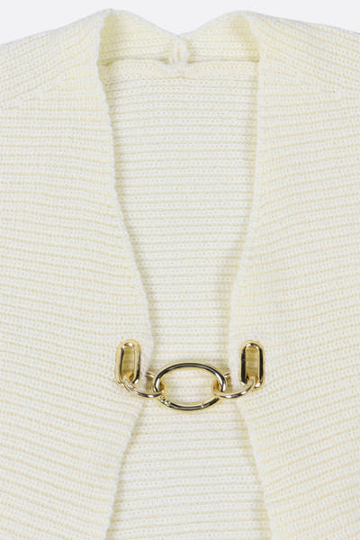 
Détail du cardigan court en maille écrue avec fermeture bijou, une pièce glamour pour un look sophistiqué.



