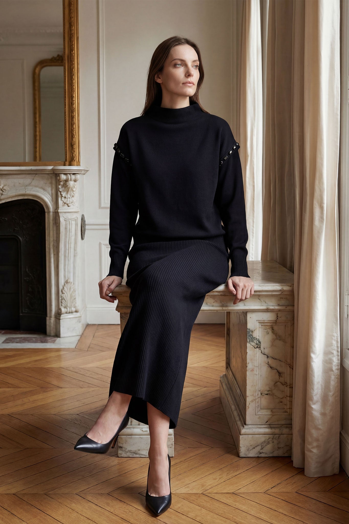 Finitions soignées du pull noir en maille et de la jupe longue, ensemble idéal pour une journée élégante au bureau.