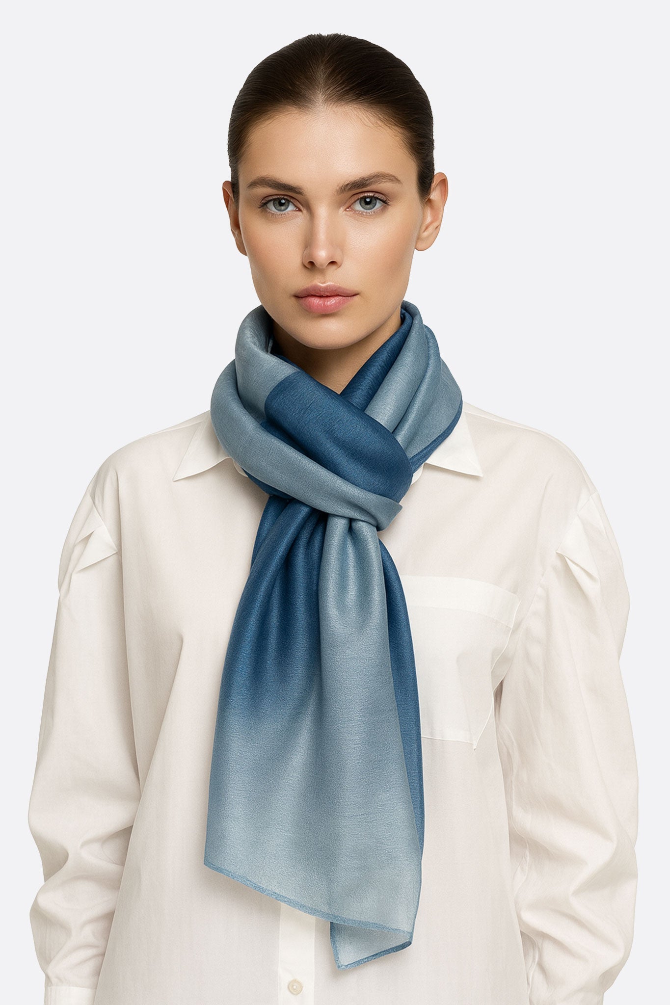 Foulard elegante in seta e cotone con tonalità blu degradé, ideale per arricchire con stile un outfit da sera o da ufficio.
