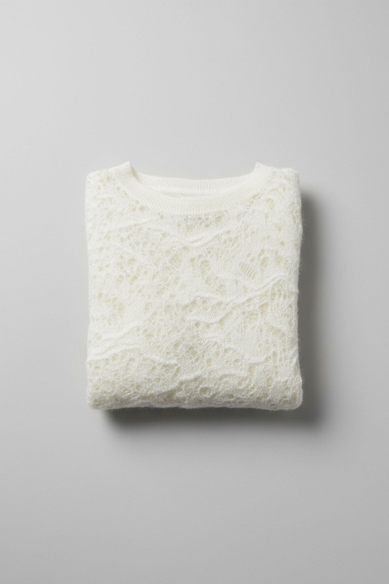 Eleganter ärmelloser Gilet aus feiner Wolle und Mohair in reinem Weiß, Detailansicht in 3/4, die weiche Textur betont.