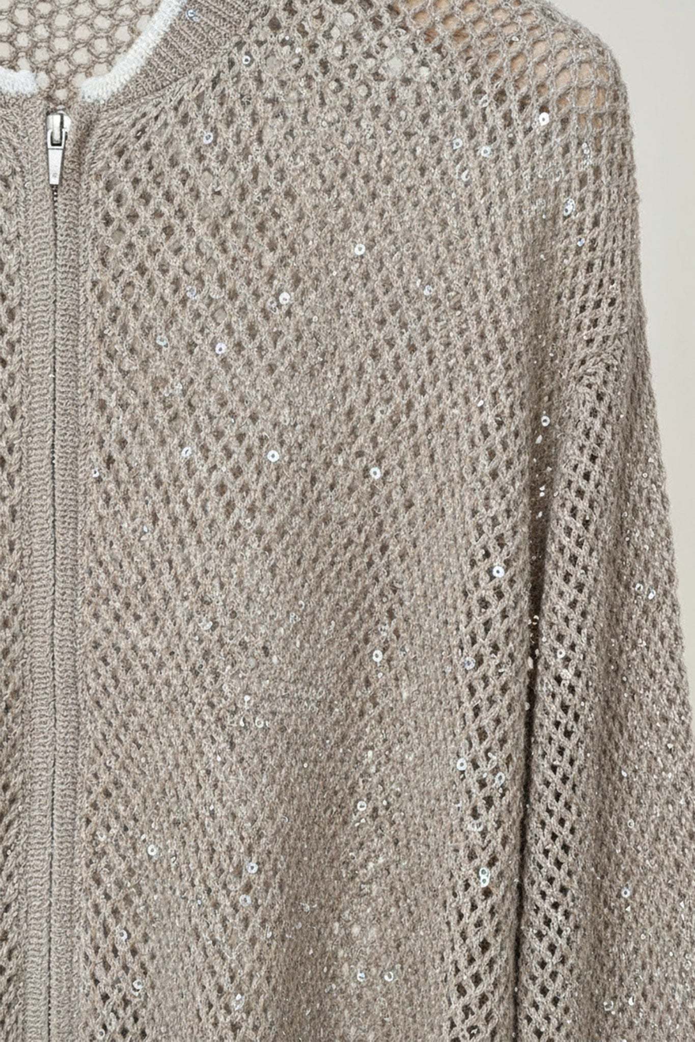 
Détail du gilet beige sable zippé en coton et tencel, ajouré et rehaussé de sequins, parfait pour un look élégant au...



