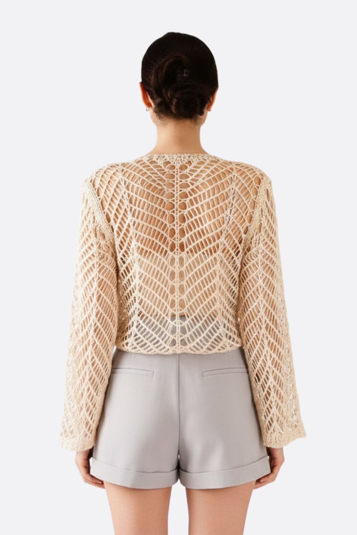 Chaqueta corta beige en tejido de crochet, diseño artesanal ajourado, perfecta para un look bohemio y elegante en verano.