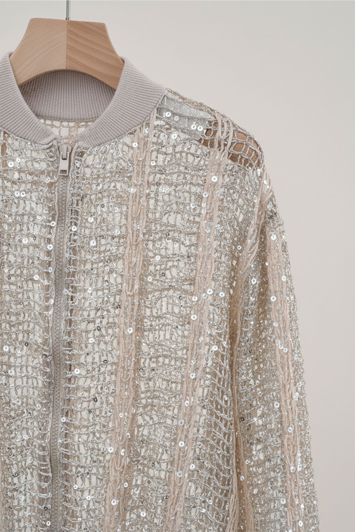 
Gilet bomber en lin et soie champagne ajouré, dévoilant des sequins brillants pour une touche d'élégance lors d'une soirée.



