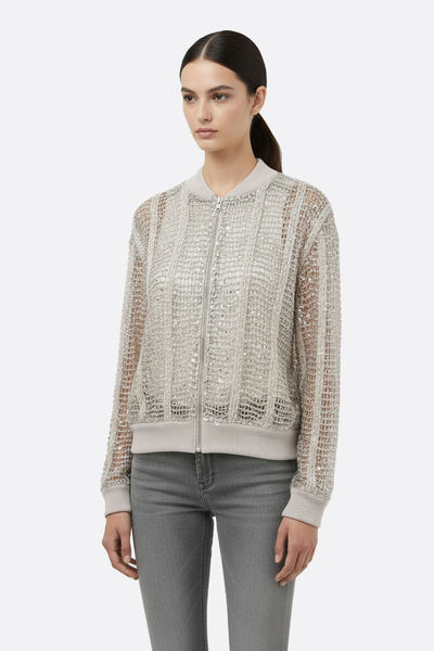 
Zoom sur le gilet bomber champagne ajouré en lin et soie, mettant en avant des sequins scintillants pour une allure chic.



