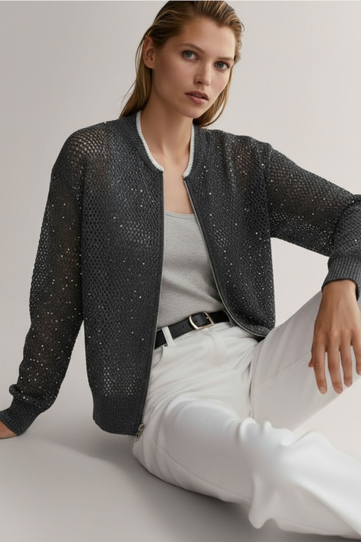 Chaqueta gris de algodón y tencel, con diseño calado y detalles brillantes de lentejuelas, ideal para ocasiones elegantes.