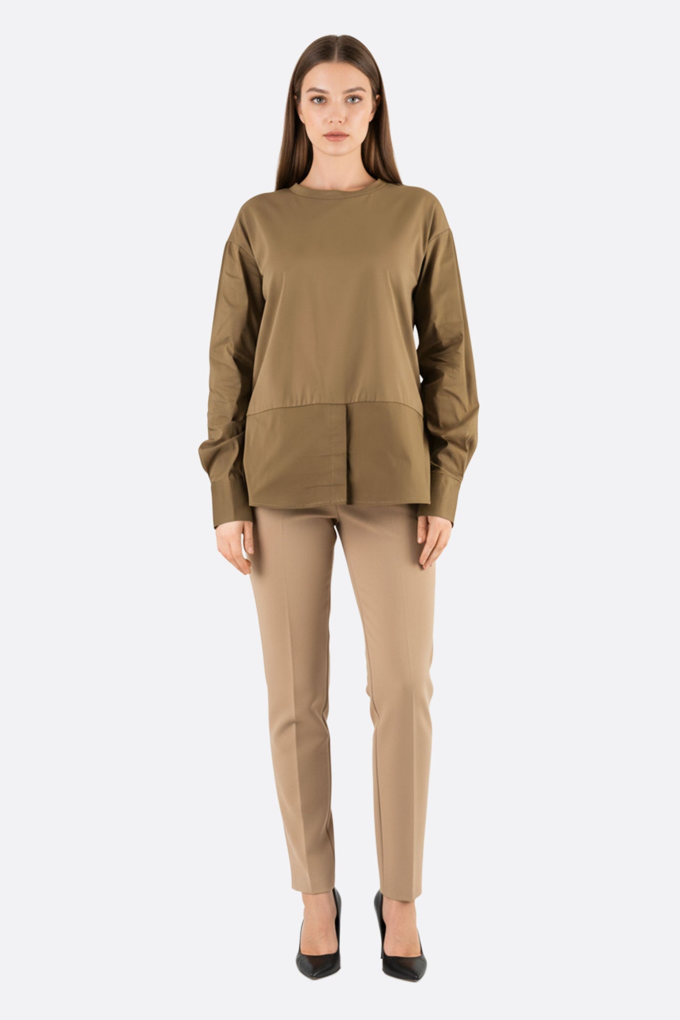 Dettaglio del top verde kaki a maniche lunghe con tessuti a contrasto, ideale per un look elegante e raffinato in...