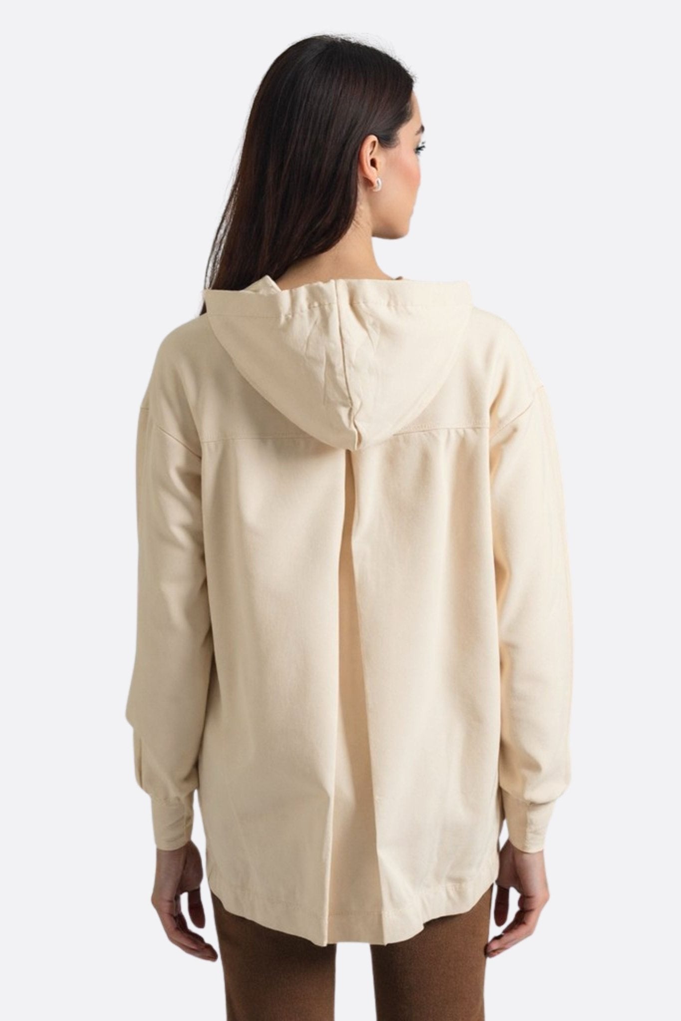 Dettaglio della texture morbida del hoodie lungo beige con cappuccio, un capo elegante e versatile perfetto per ogni...