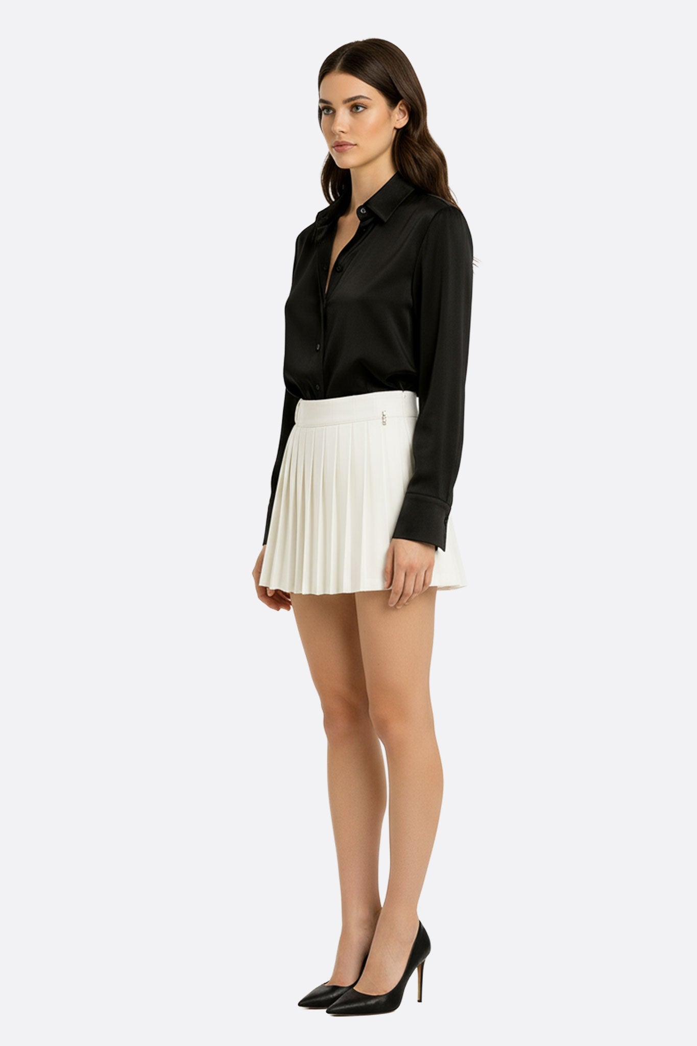 Vue alternative de la jupe blanche courte à plis, illustrant sa fluidité et son élégance pour un look intemporel au...