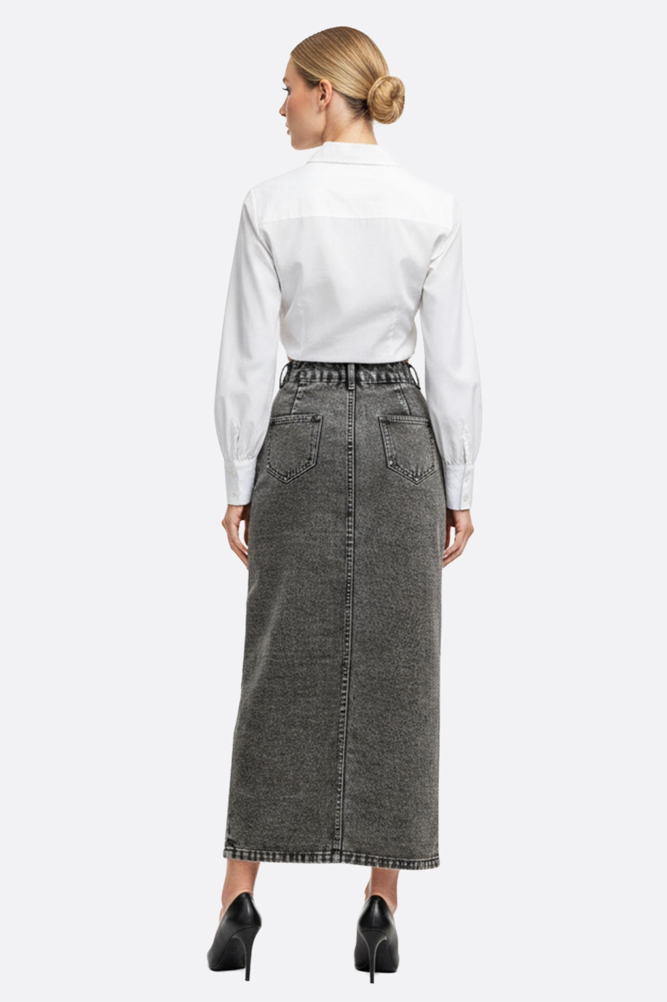 Détail de la jupe longue en denim gris avec boutons, un choix raffiné pour une tenue décontractée et tendance.