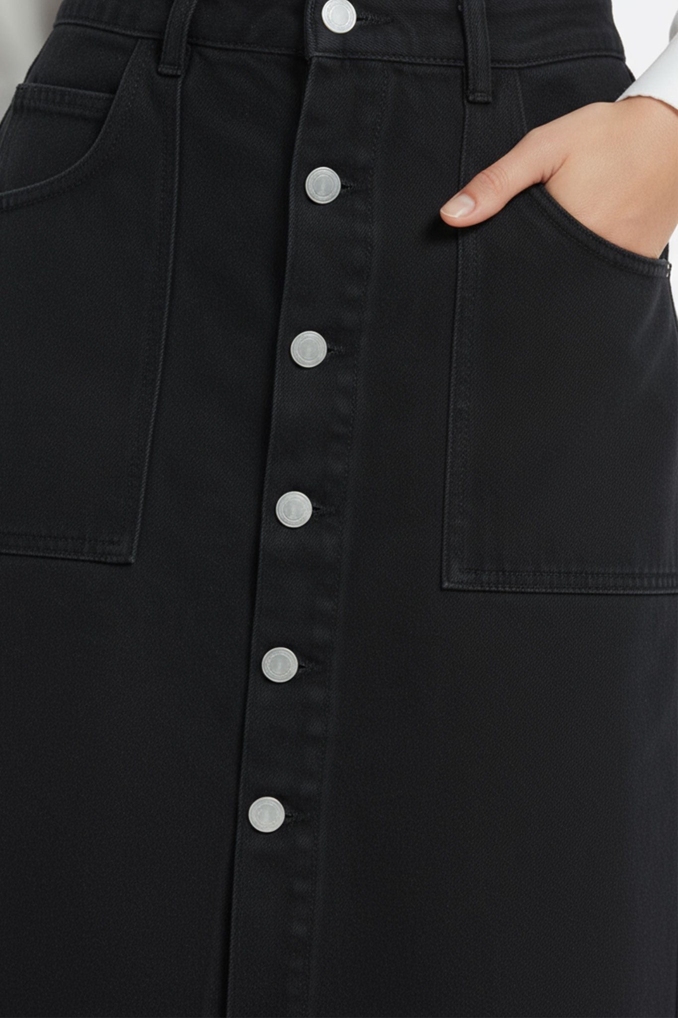 
Perspective alternative de la jupe en denim noir à poches surdimensionnées, une pièce élégante pour des occasions...



