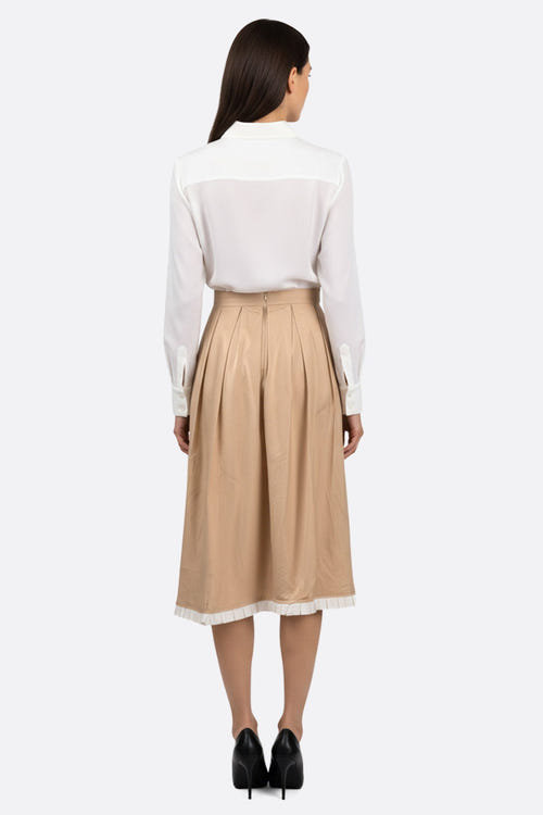 
Zoom sur la jupe midi plissée beige avec ses bords contrastants, idéale pour une tenue élégante en toute occasion.



