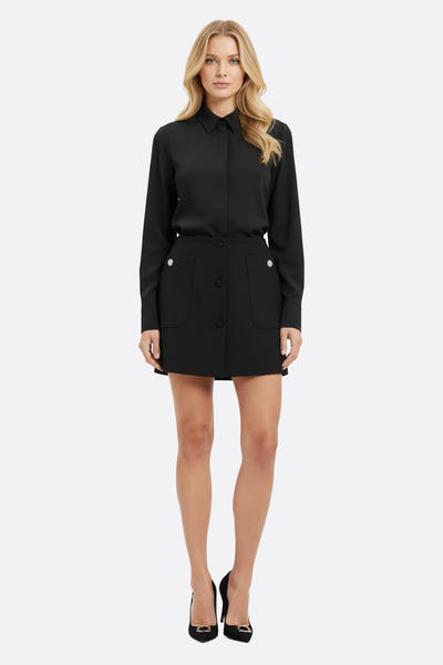 
Jupe noire courte en tissu fluide, ornée de boutons bijoux et de poches oversize, idéale pour un look élégant de soirée.



