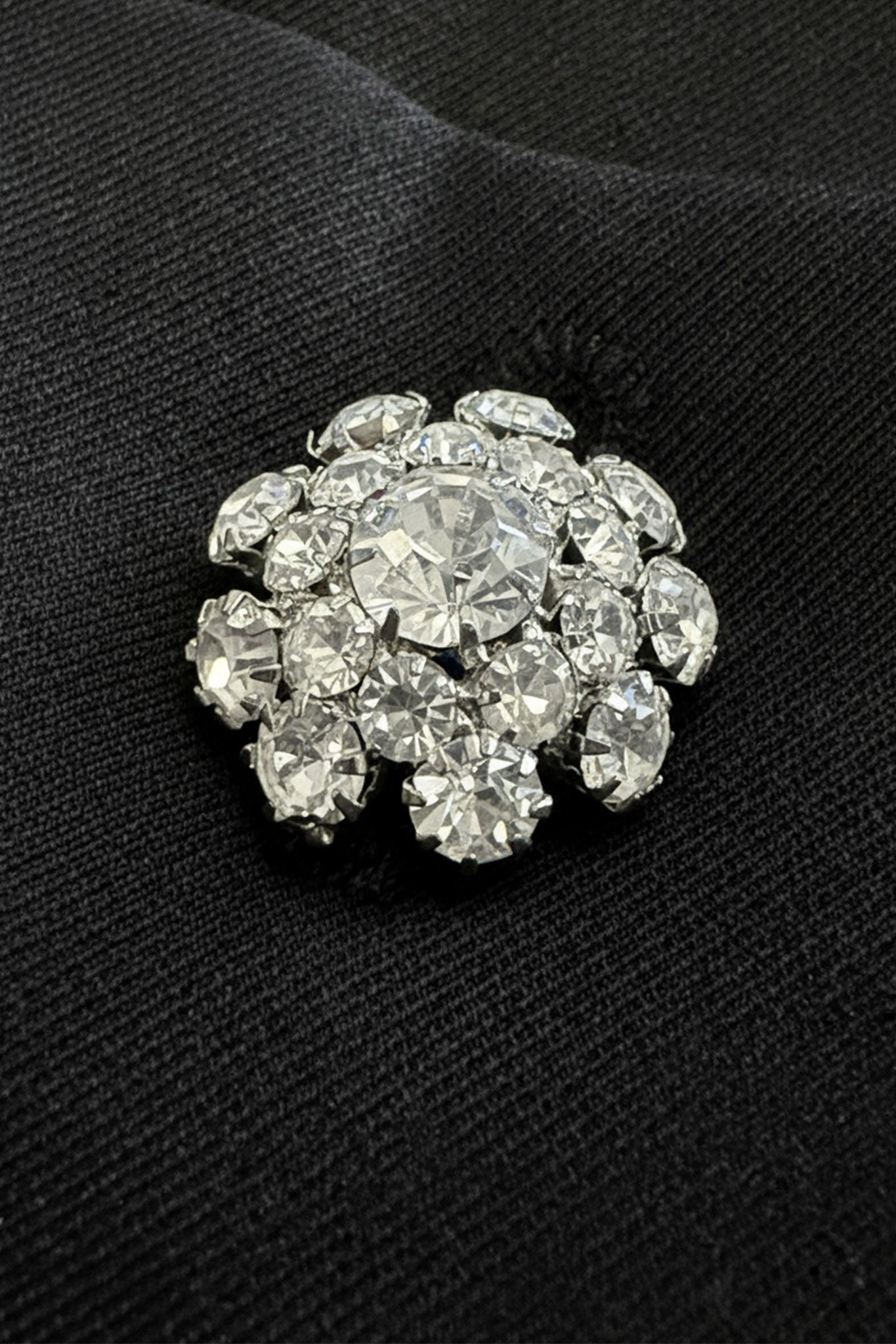 
Détail de la jupe noire courte avec poches oversize, soulignant la finition délicate des boutons bijoux et sa texture...



