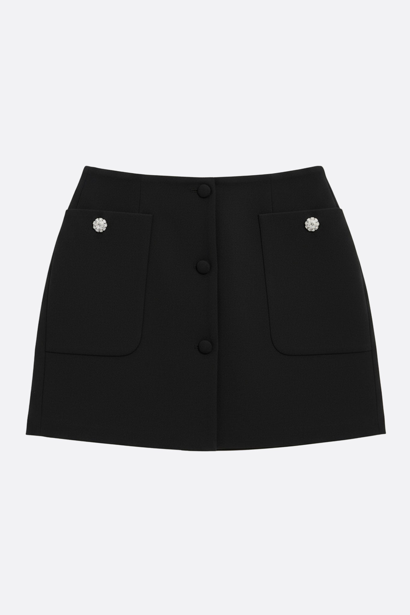 Jupe noire à poches larges et boutons bijoux, vue 3/4, mettant en avant sa coupe droite et son allure chic pour toutes...