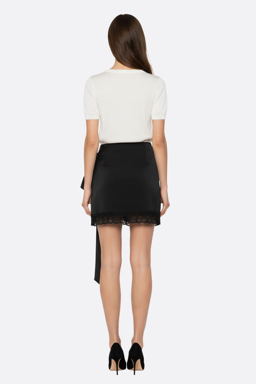 
Zoom sur la jupe noire en satin et dentelle, révélant son design asymétrique et sa texture luxueuse, idéale pour le...



