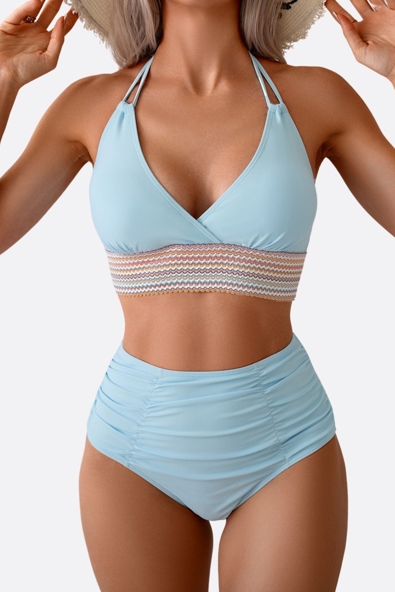 
Bikini bleu pastel à la taille haute, mettant en avant une bande multicolore, parfait pour une escapade estivale chic.



