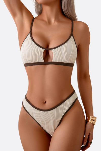 
Zoom sur le maillot de bain deux-pièces beige avec liseré marron, révélant sa texture ondulée pour un look chic à la plage.



