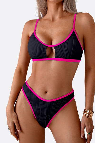 
Détail du maillot de bain deux-pièces noir élégant avec liseré rose, mettant en valeur la découpe raffinée du haut.



