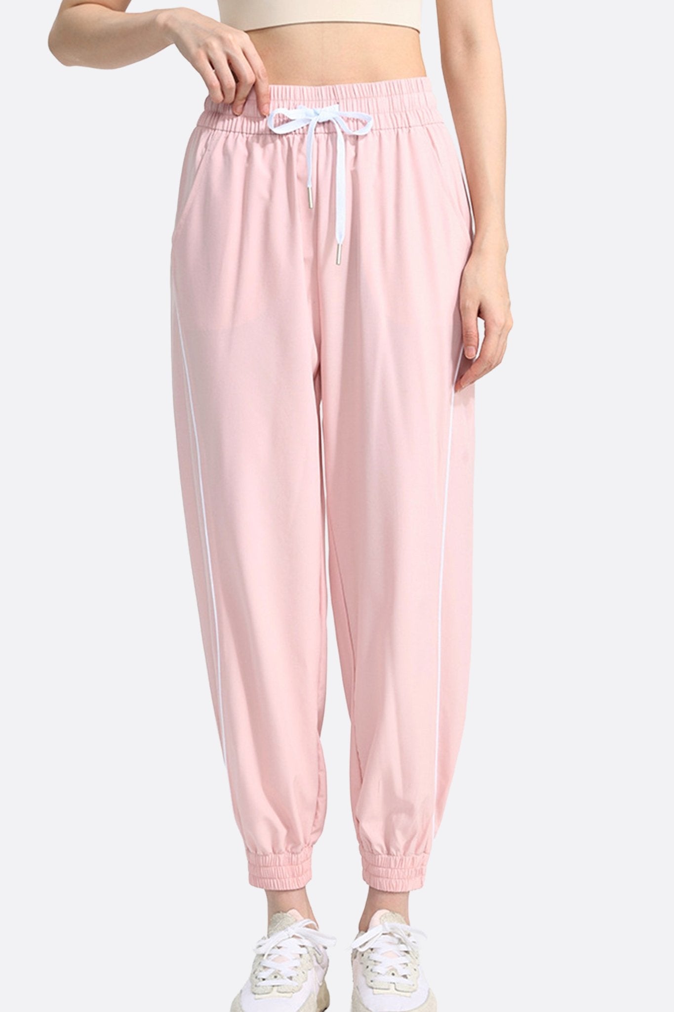 Dettaglio sui pantaloni sportivi rosa per donna, in morbido tessuto, perfetti per un look chic e confortevole nella vita...