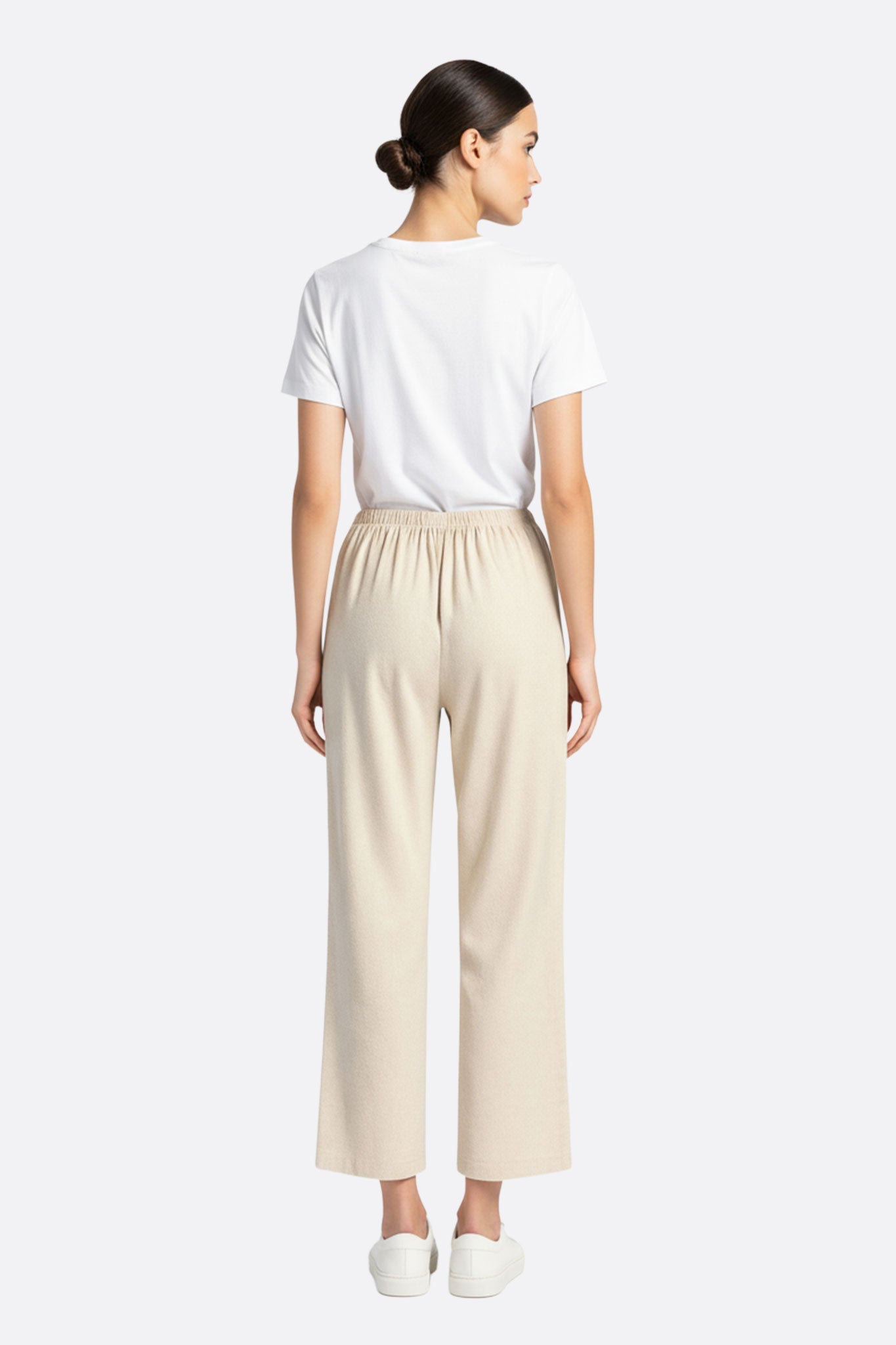 
Détail du pantalon en lin beige à taille élastique, illustrant sa texture légère et son confort idéal pour les sorties...



