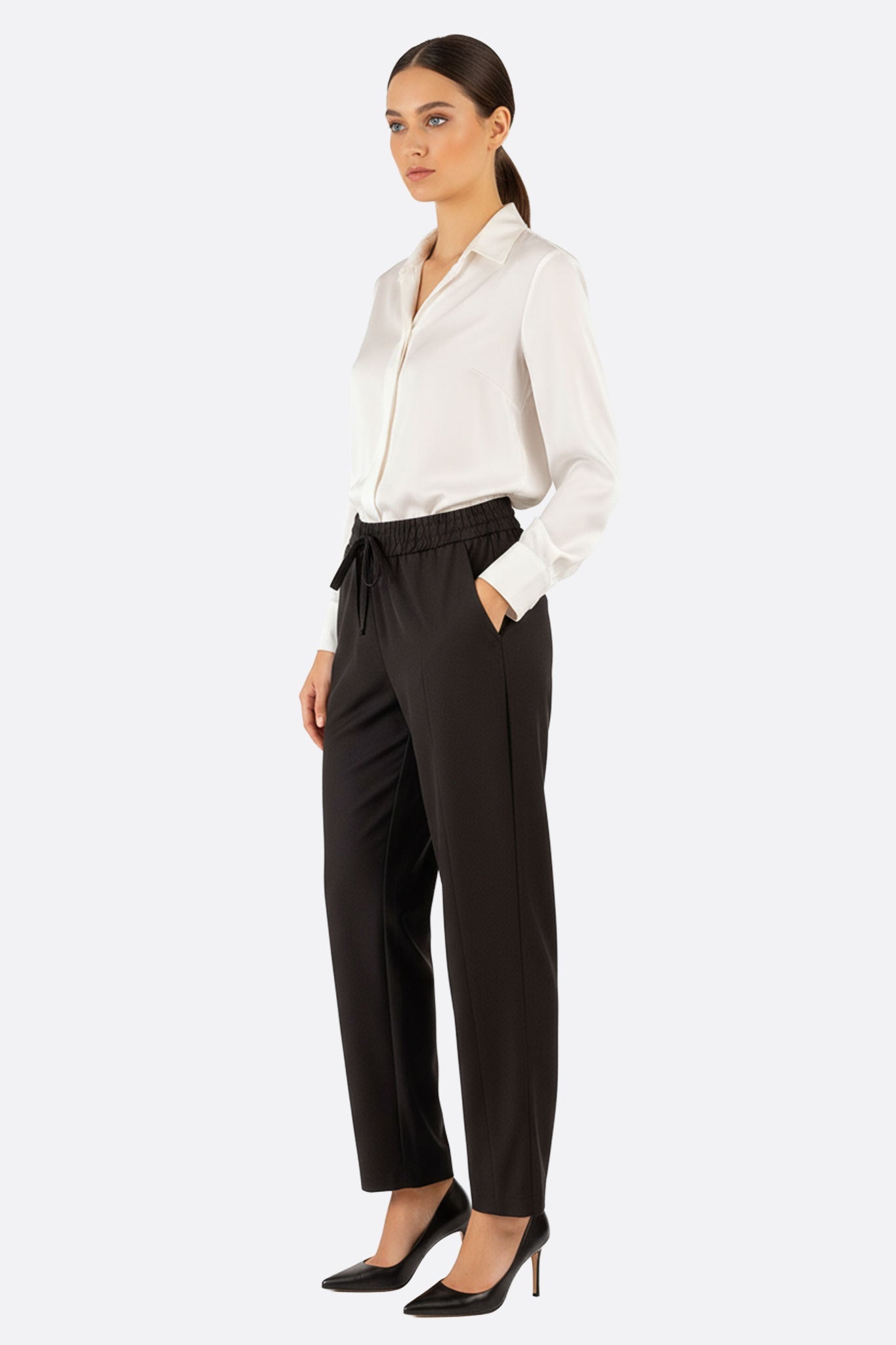 Pantalon noir décontracté à taille élastique, vue 3/4 mettant en valeur sa coupe moderne et son tissu léger parfait pour...