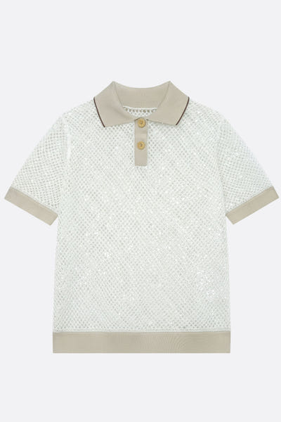 
Détail latéral d'un polo ivoire en maille ajourée, manches courtes, illuminé par des sequins délicats, parfait pour un...



