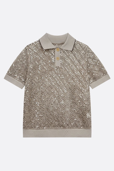 
Zoom sur la maille ajourée d'un polo beige sablé, embellie de sequins ton sur ton, parfait pour une élégance estivale.



