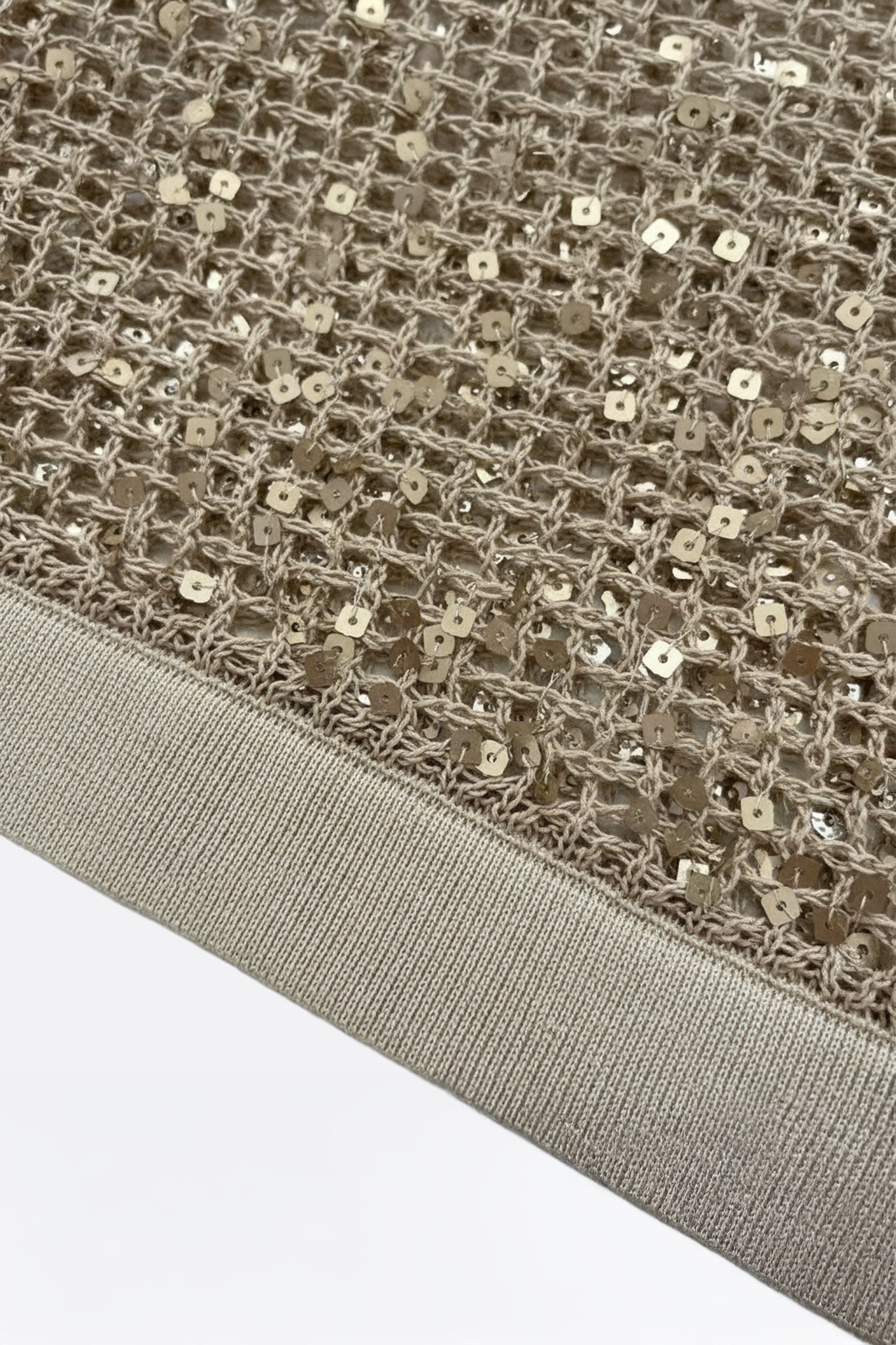 
Zoom sur les sequins ton sur ton d'un polo beige sablé en maille ajourée, idéal pour un style estival élégant et raffiné.



