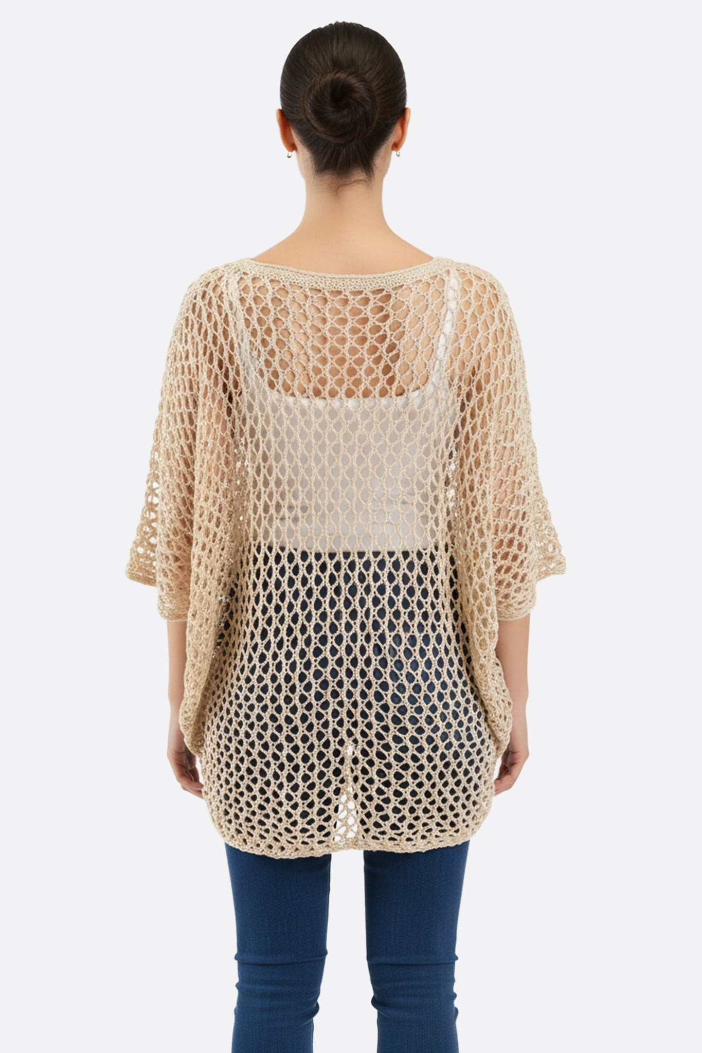 Détail alternatif du poncho beige en maille ajourée, motif étoile, pour un look bohème chic et aérien.