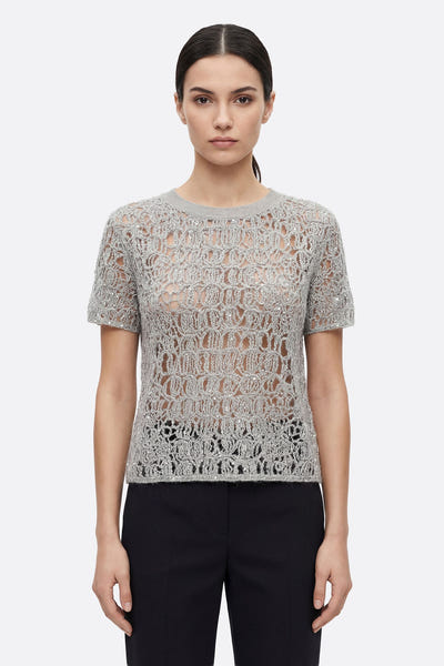 
Pull gris perle en maille ajourée de mohair et lurex, à manches courtes, parfait pour un look chic en soirée.



