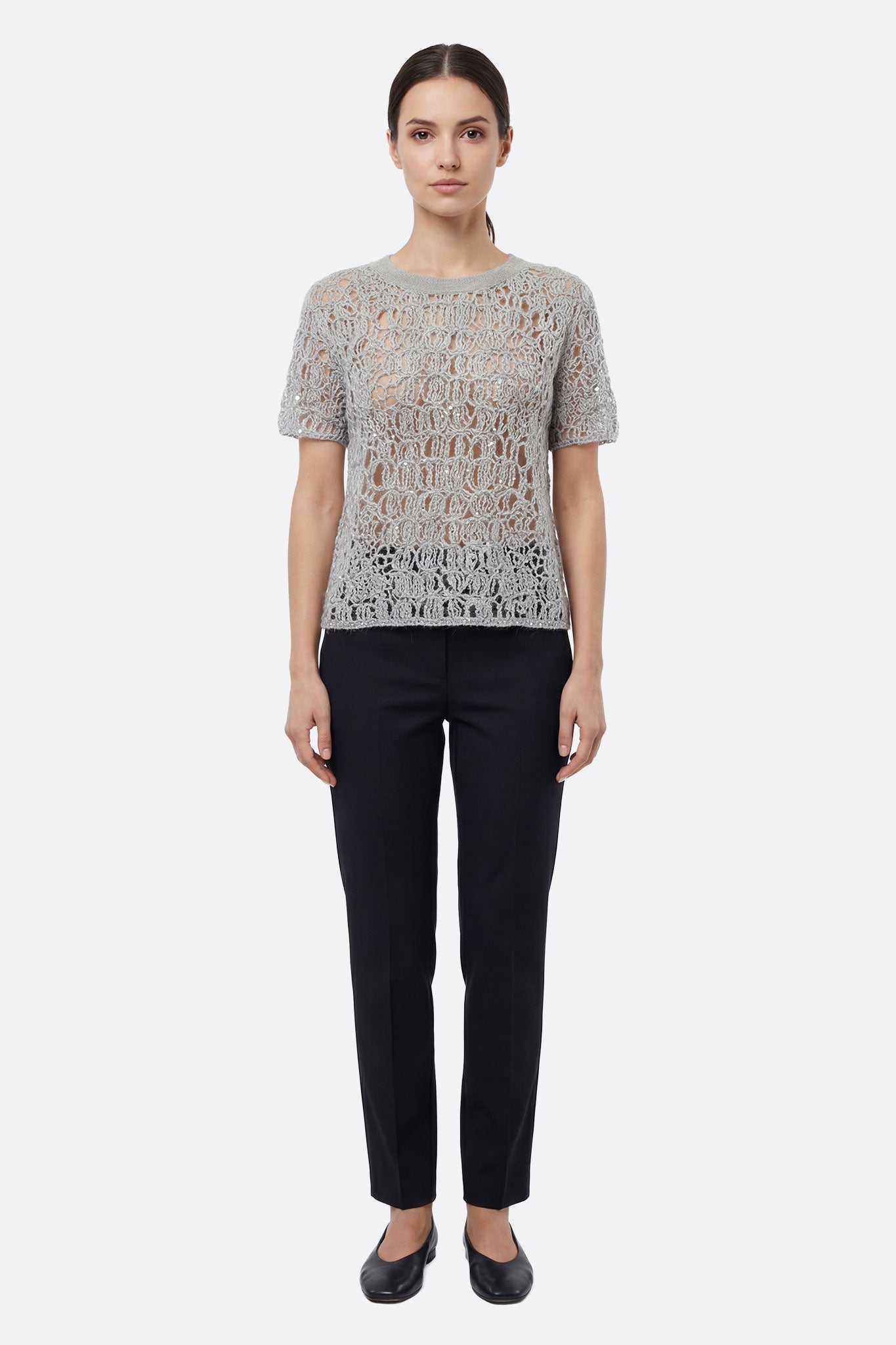 
Détail captivant du pull en maille ajourée gris perle avec lurex, une pièce chic pour rehausser une tenue estivale.



