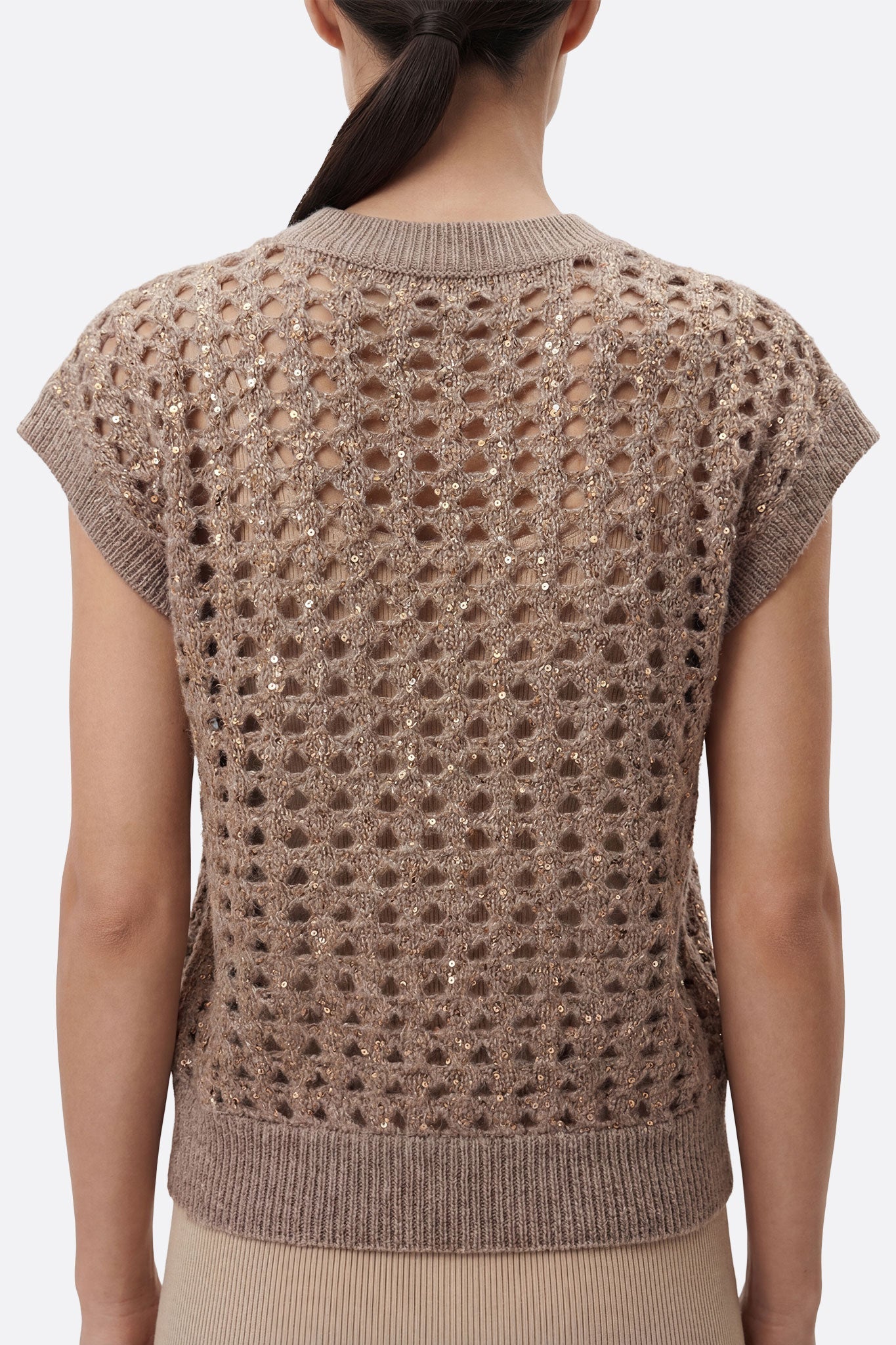 Détail alternatif du pull ajouré sans manches gris taupe, mettant en avant l'éclat subtil des sequins pour une touche...